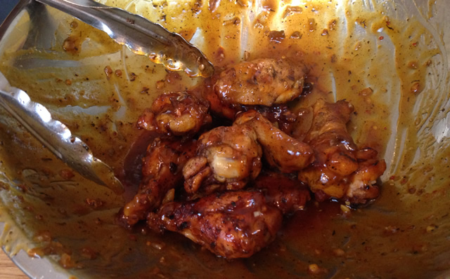 tossing chicken wings in sauce - Caribbean Style Hot Wings